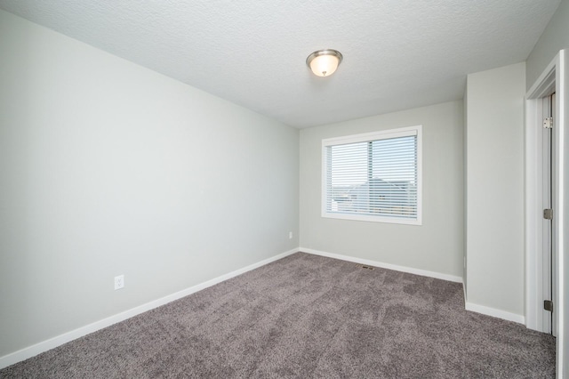 carpeted spare room with a textured ceiling