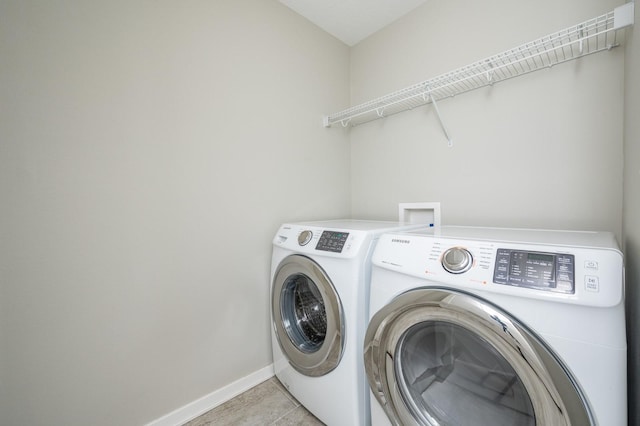 clothes washing area featuring light tile patterned floors and washer and clothes dryer