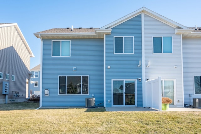 back of house with cooling unit and a yard