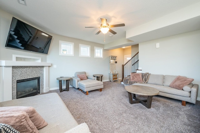 living room with ceiling fan, carpet, and a tiled fireplace