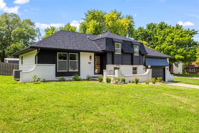 view of front of property with a garage, a front yard, and central AC