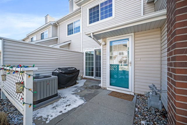 doorway to property with cooling unit and a patio area