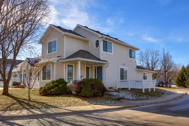 view of front facade with a wooden deck and a front yard