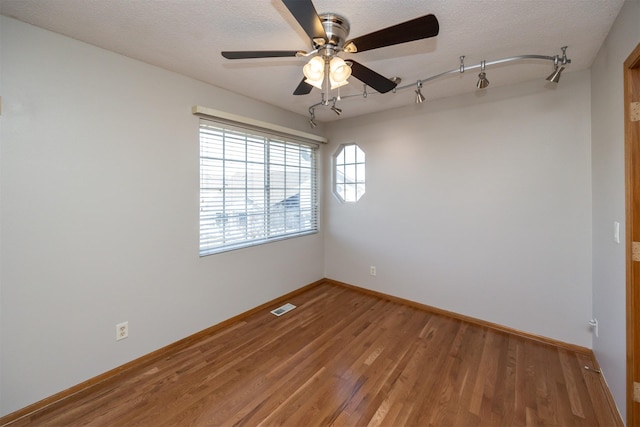 unfurnished room with visible vents, baseboards, a textured ceiling, and light wood-style flooring