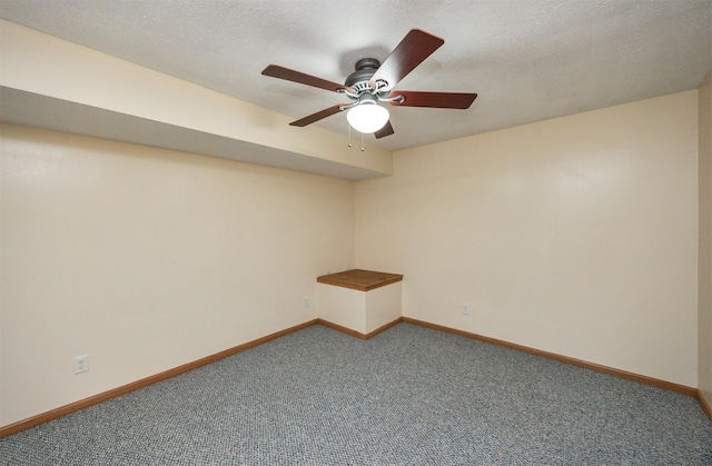 spare room with ceiling fan, carpet, baseboards, and a textured ceiling