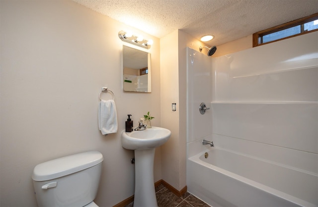 bathroom featuring baseboards, toilet, bathtub / shower combination, tile patterned floors, and a textured ceiling