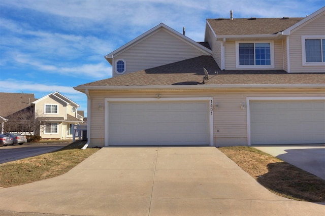 view of front facade with concrete driveway and roof with shingles