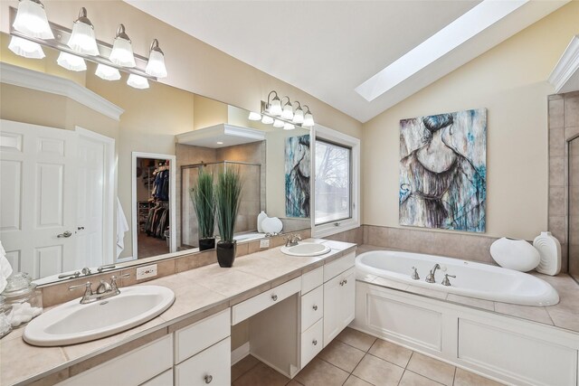 full bathroom with a walk in closet, a sink, vaulted ceiling with skylight, double vanity, and a stall shower