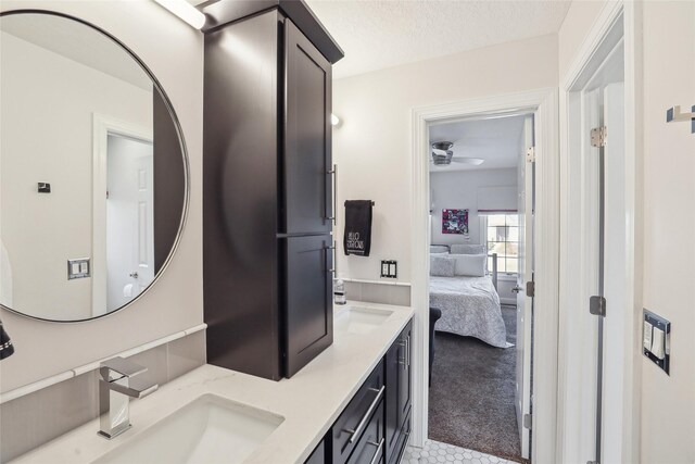 bathroom with a textured ceiling, ceiling fan, and vanity