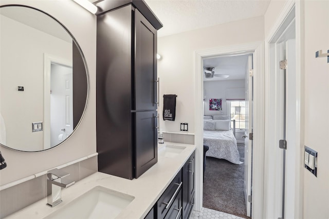 bathroom featuring double vanity, a sink, ceiling fan, and ensuite bathroom