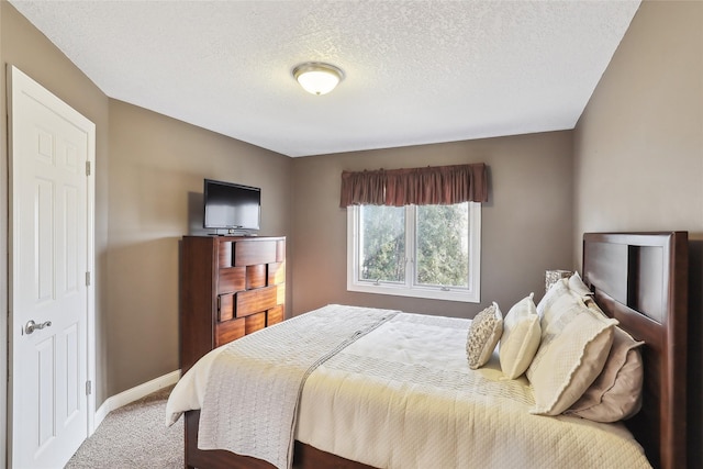 carpeted bedroom with baseboards and a textured ceiling