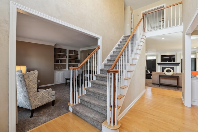 staircase with crown molding and hardwood / wood-style flooring