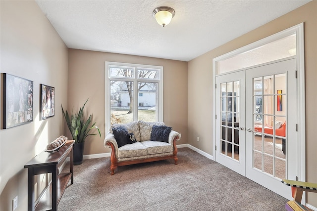 sitting room featuring carpet floors, baseboards, french doors, and a textured ceiling