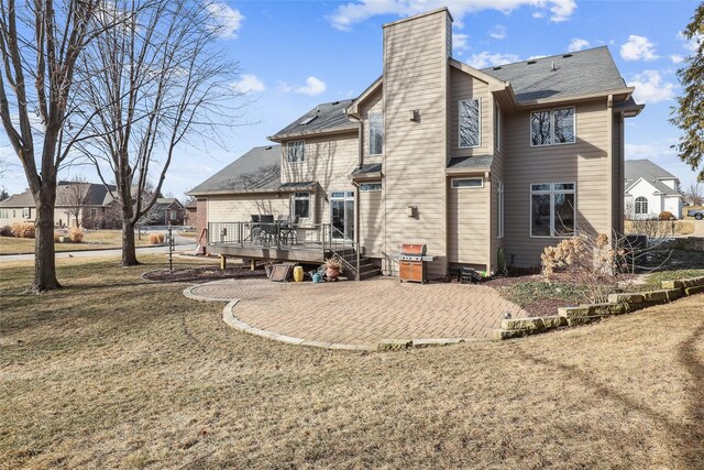 back of house with a deck, a patio area, and a yard