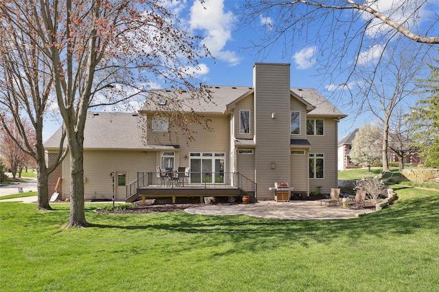 rear view of property featuring a lawn, a patio, a chimney, and a deck