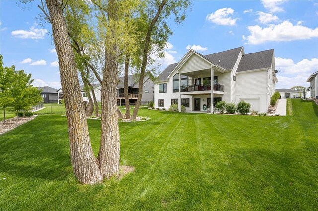 back of house with a lawn and a balcony