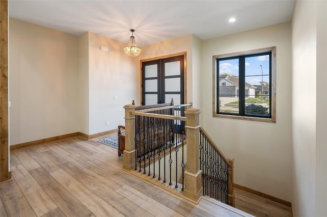 stairway featuring a notable chandelier and hardwood / wood-style floors