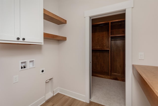 washroom with light hardwood / wood-style floors, hookup for an electric dryer, hookup for a washing machine, and cabinets