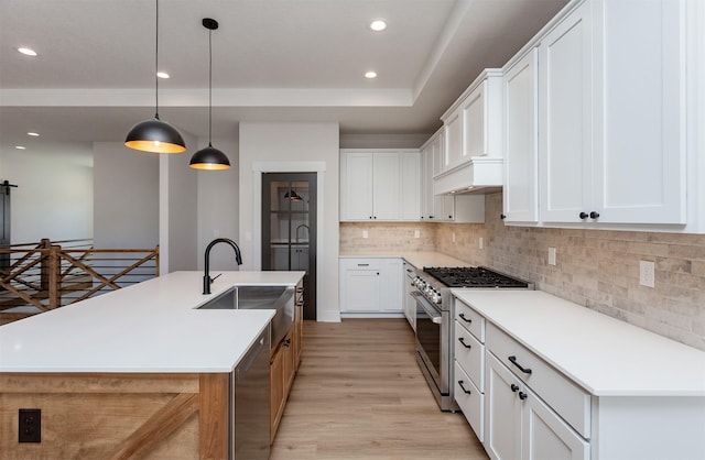 kitchen with a spacious island, sink, white cabinetry, hanging light fixtures, and stainless steel appliances