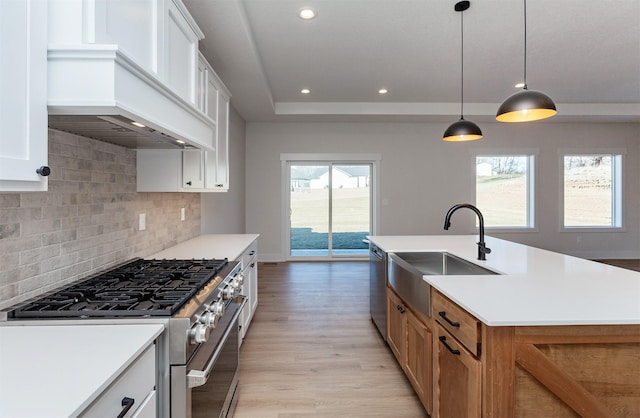 kitchen with white cabinetry, appliances with stainless steel finishes, and an island with sink