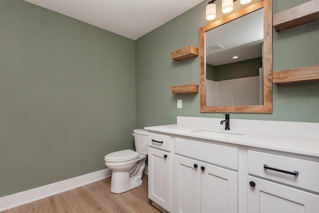 bathroom with toilet, vanity, and hardwood / wood-style flooring