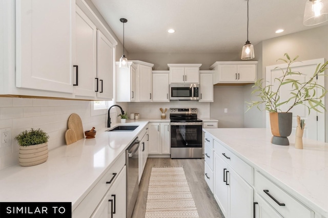 kitchen with white cabinets, appliances with stainless steel finishes, and sink