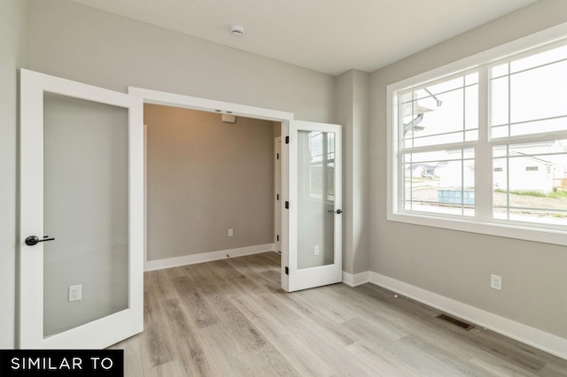 unfurnished bedroom featuring light hardwood / wood-style floors and french doors