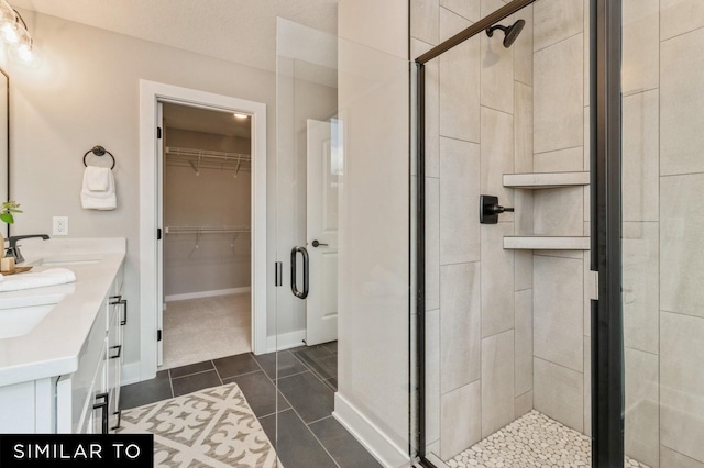 bathroom with tile patterned floors, walk in shower, and vanity