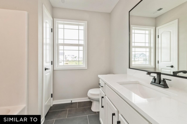 bathroom featuring a bathtub, toilet, vanity, and tile patterned flooring