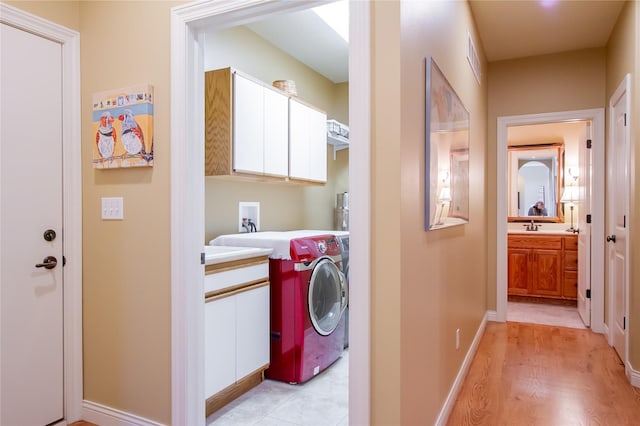 laundry room featuring light hardwood / wood-style floors, sink, and washer / clothes dryer