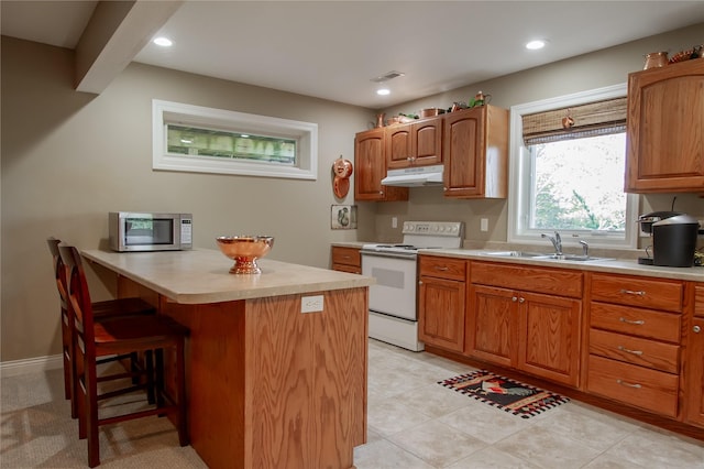 kitchen with a breakfast bar area, white electric range oven, and sink