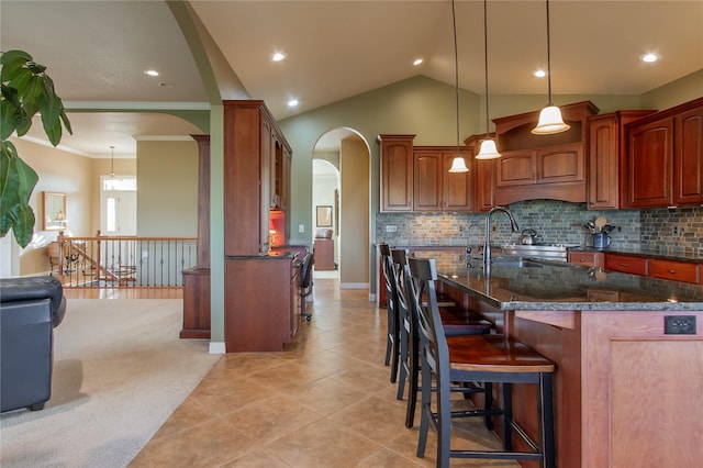 kitchen featuring vaulted ceiling, sink, a breakfast bar area, and pendant lighting