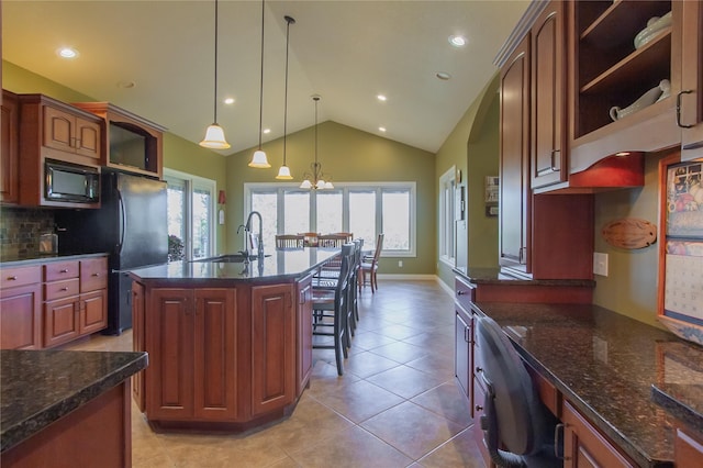 kitchen featuring a center island with sink, a notable chandelier, decorative light fixtures, black appliances, and sink