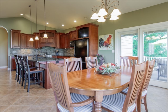 dining space with light tile patterned flooring, lofted ceiling, and a notable chandelier