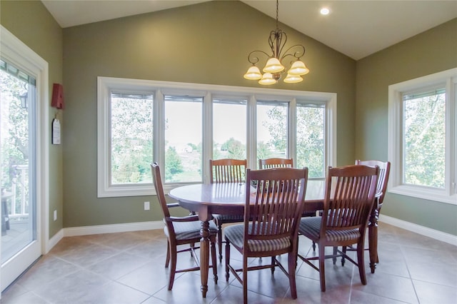 tiled dining area with a healthy amount of sunlight, vaulted ceiling, and a chandelier