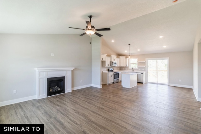 unfurnished living room with lofted ceiling, wood-type flooring, and ceiling fan