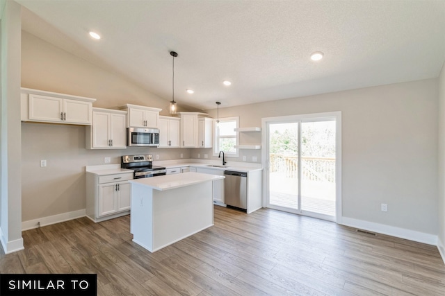 kitchen featuring white cabinetry, appliances with stainless steel finishes, sink, pendant lighting, and a center island