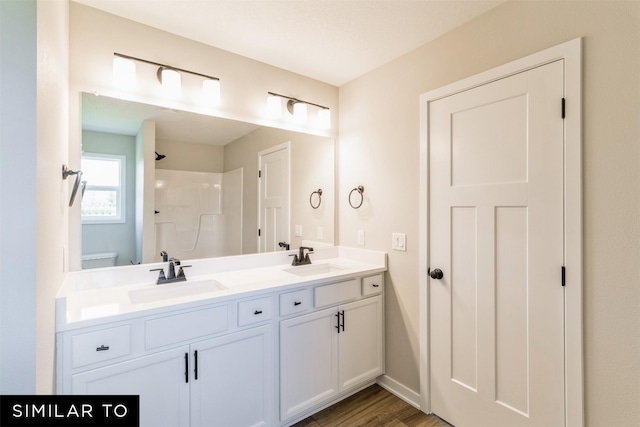 bathroom featuring a shower, hardwood / wood-style floors, toilet, and vanity