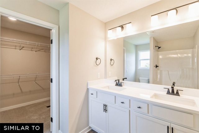 bathroom with toilet, vanity, and a shower