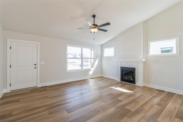 4207 NE 3rd St, Ankeny, IA 50021 - unfurnished living room with lofted ceiling, wood finished floors, visible vents, a ceiling fan, and a glass covered fireplace