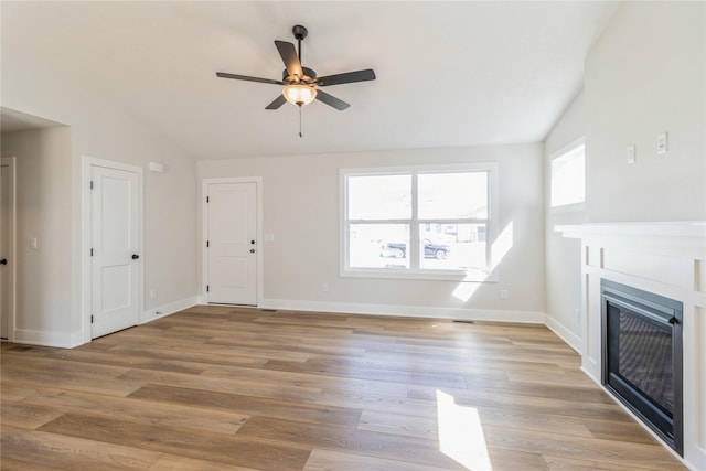 4207 NE 3rd St, Ankeny, IA 50021 - unfurnished living room with vaulted ceiling, a ceiling fan, light wood-type flooring, a fireplace, and baseboards