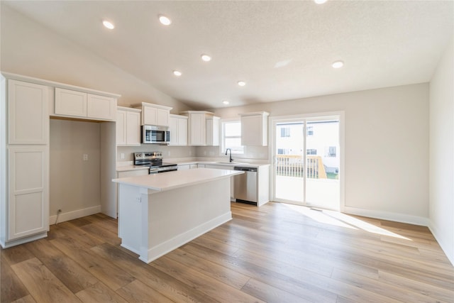 4207 NE 3rd St, Ankeny, IA 50021 - kitchen featuring a center island, light wood-type flooring, stainless steel appliances, light countertops, and white cabinets