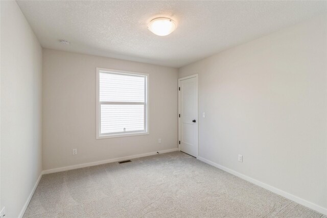 4207 NE 3rd St, Ankeny, IA 50021 - unfurnished room featuring baseboards, a textured ceiling, visible vents, and carpet