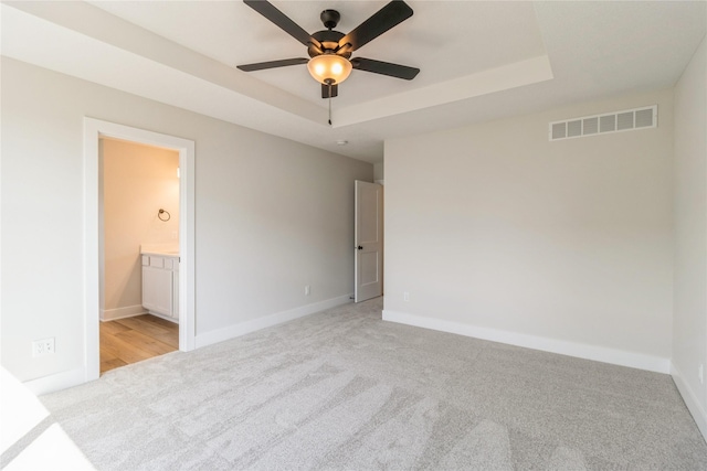 4207 NE 3rd St, Ankeny, IA 50021 - unfurnished bedroom with a raised ceiling, visible vents, ensuite bath, baseboards, and light colored carpet