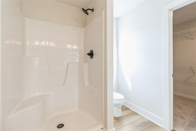 4207 NE 3rd St, Ankeny, IA 50021 - full bathroom featuring a walk in closet, baseboards, toilet, and a stall shower