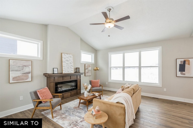 living room with ceiling fan, vaulted ceiling, and dark wood-type flooring