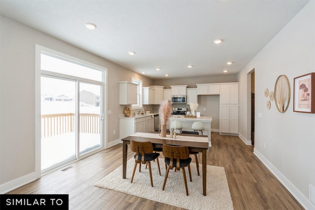 dining space with light hardwood / wood-style flooring and sink