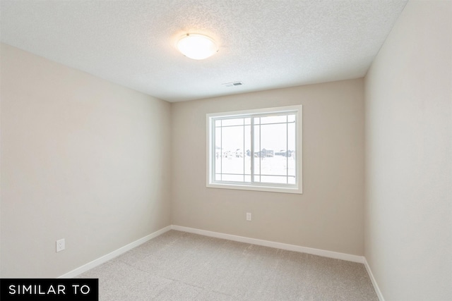 empty room featuring a textured ceiling and carpet flooring