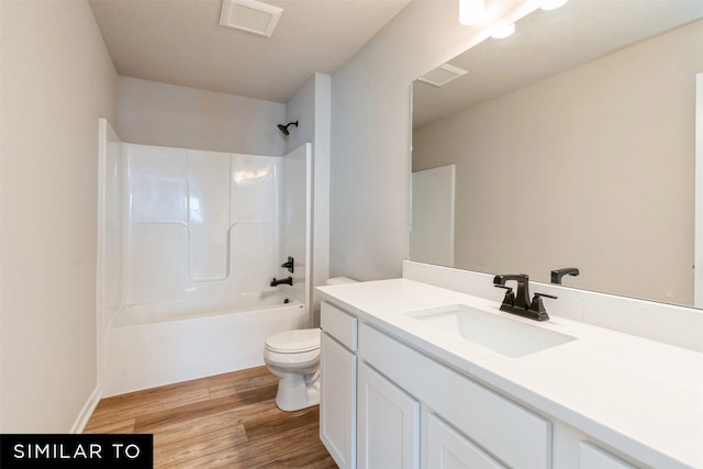 full bathroom featuring toilet, vanity, wood-type flooring, and  shower combination