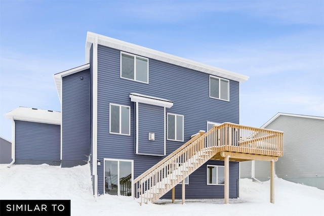 snow covered rear of property with a wooden deck